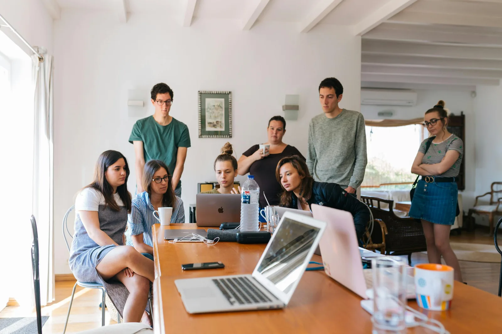 A team working together around laptops at a shared table.